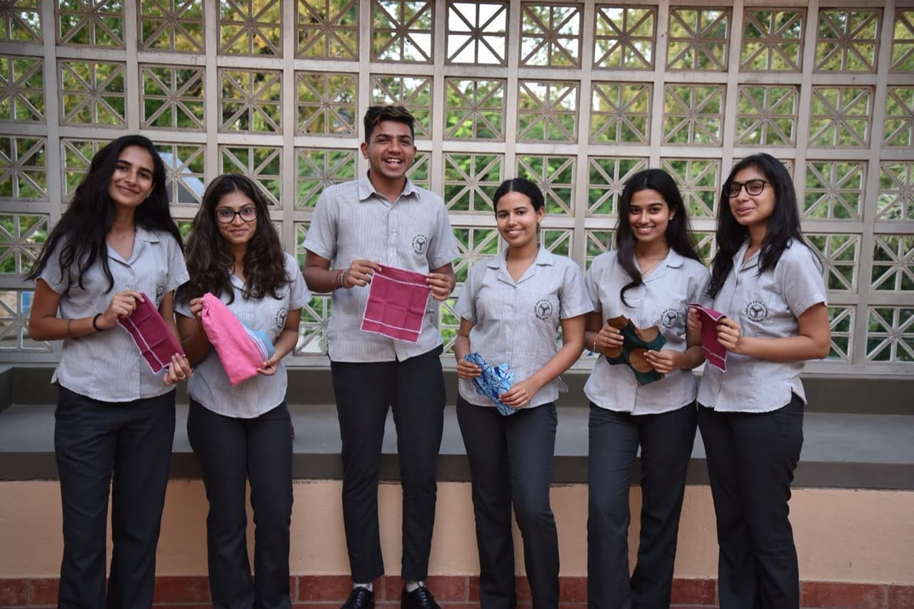 The first team, in school uniform, holding the reusable products they made